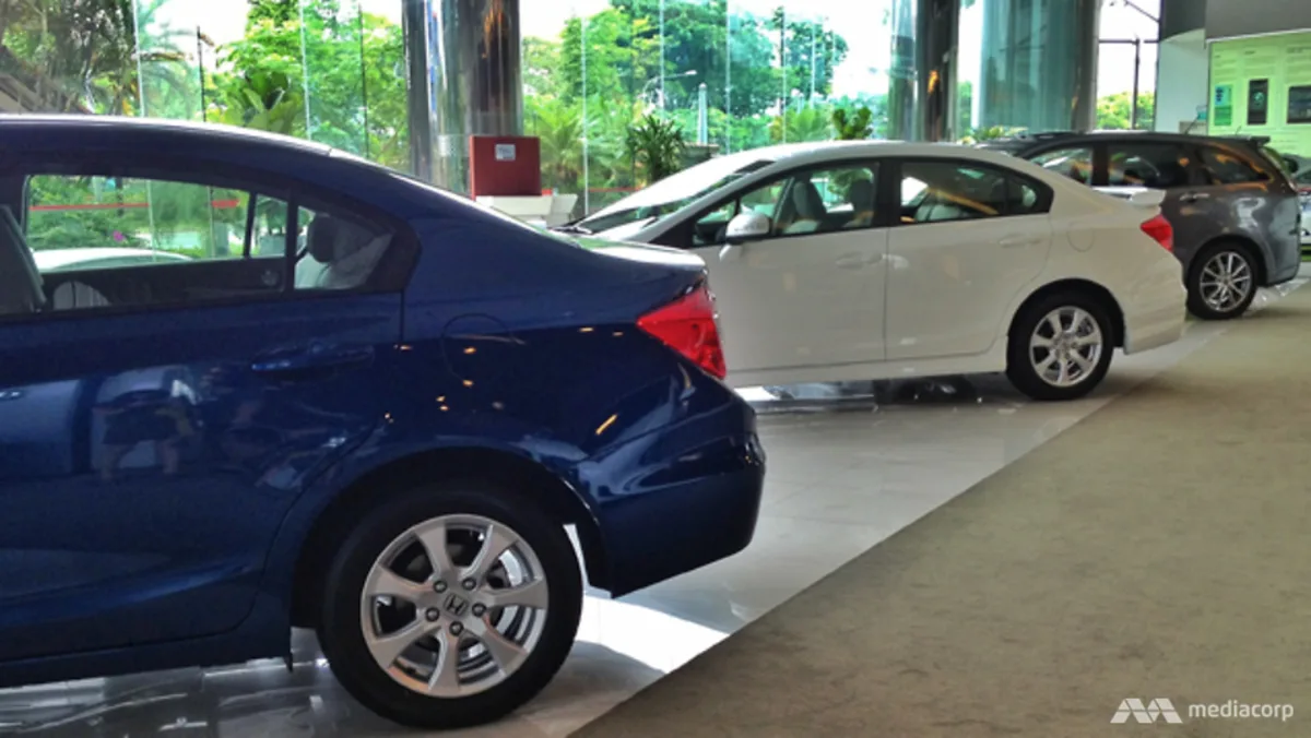 Deretan mobil di dalam ruang pamer showroom kendaraan di Singapura.