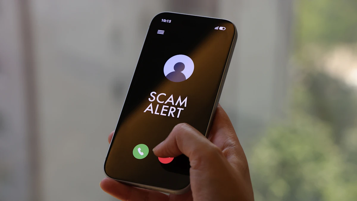 Ilustrasi peringatan penipuan online dan scam alert di ponsel pintar