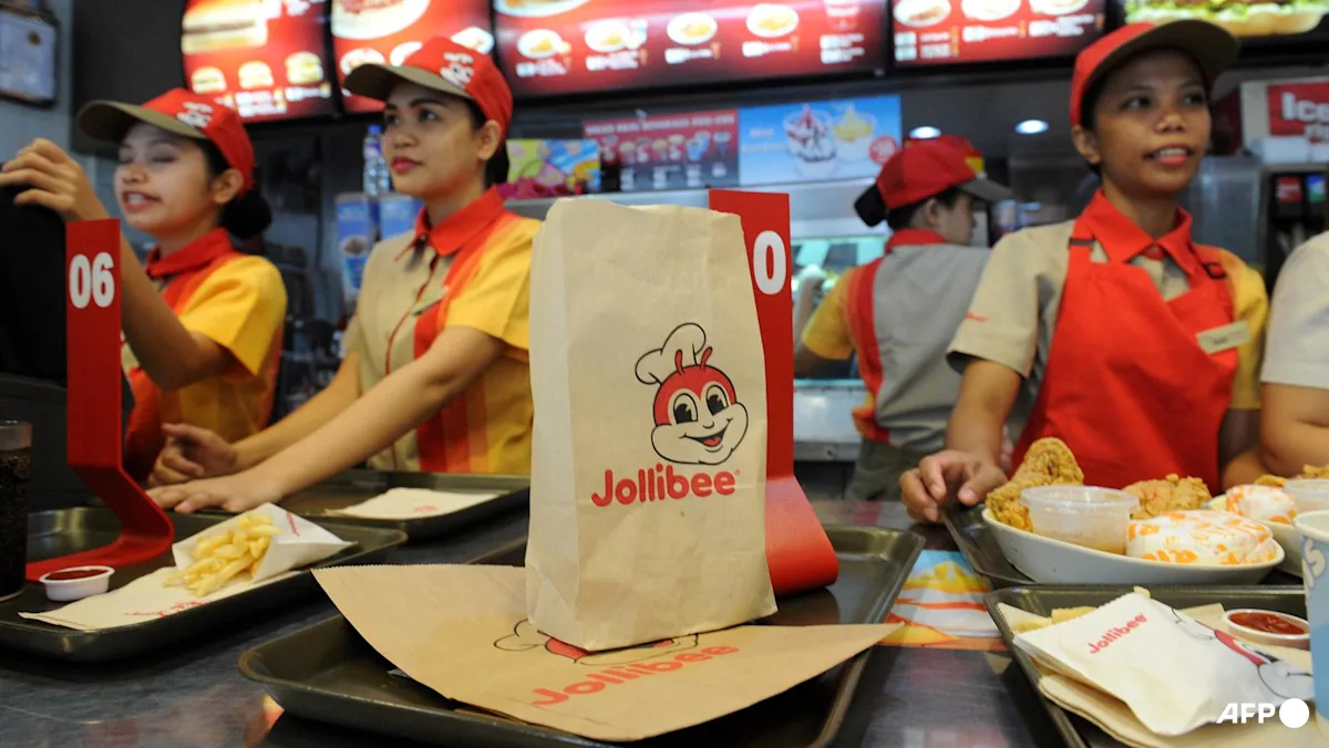 Karyawan Jollibee melayani pesanan pelanggan di gerai Manila