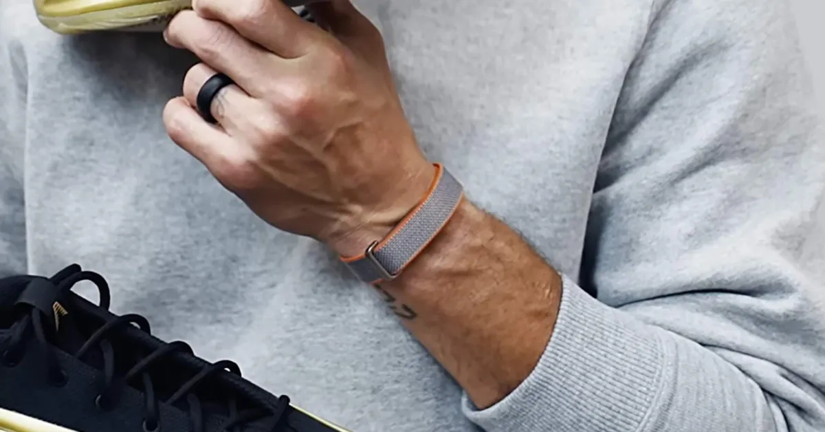 Perangkat pelacak kebugaran Fitbit di sebelah perangkat jam tangan pintar