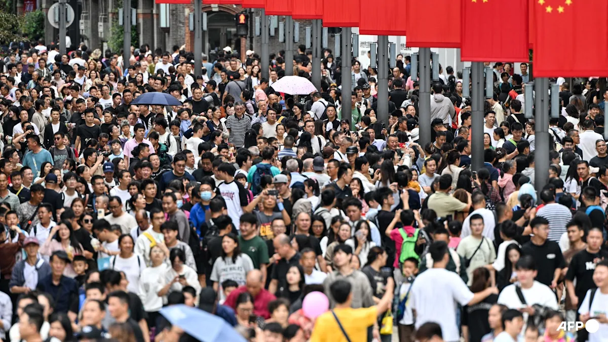 Warga berjalan di sepanjang kawasan The Bund saat perayaan Hari Nasional China di Shanghai