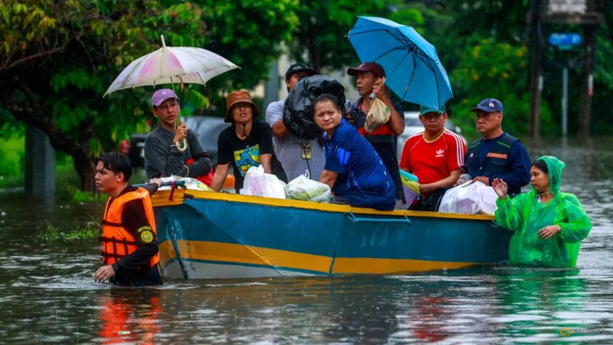 Warga menaiki perahu melewati jalanan yang terendam banjir di Bangkok