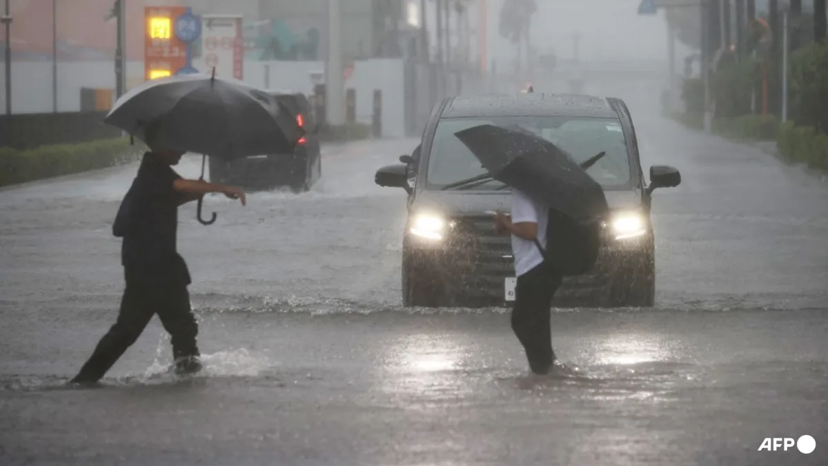 Warga menerobos genangan banjir akibat badai Topan Dujuan di Jepang