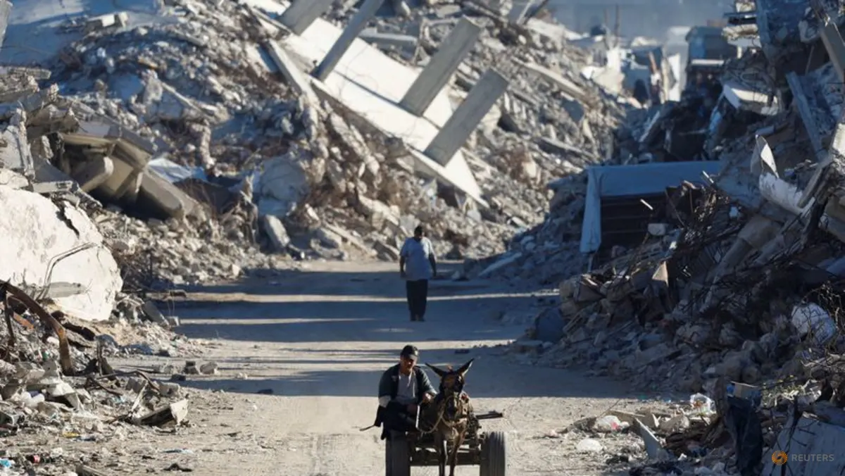 Warga Palestina melintas di antara reruntuhan bangunan akibat perang di Gaza City